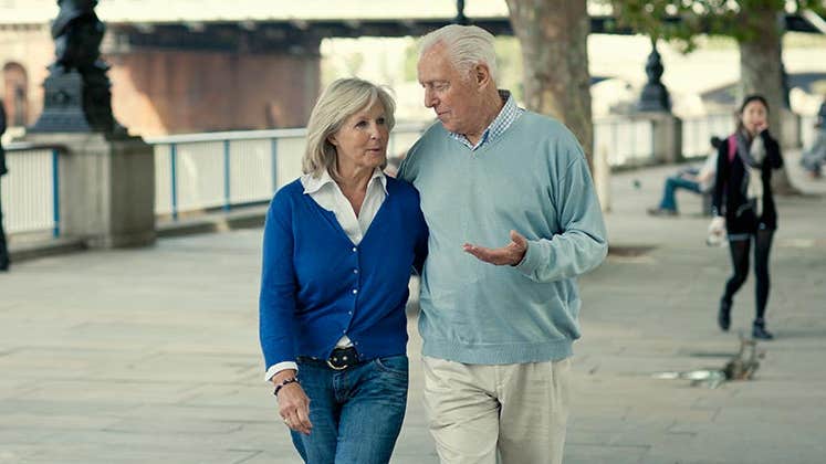 Older couple walking along bridge, talking | VisitBritain/Getty Images