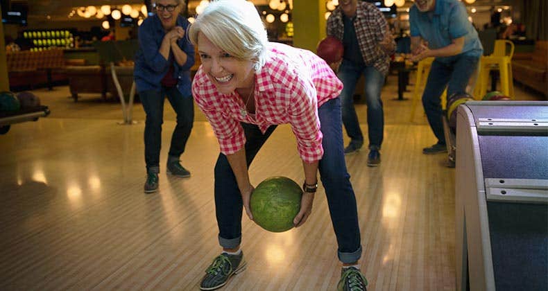Mature woman and friends bowling | Hero Images/Getty Images