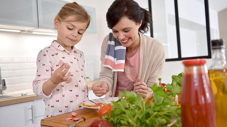 Mom preparing food with her child © goodluz/Shutterstock.com