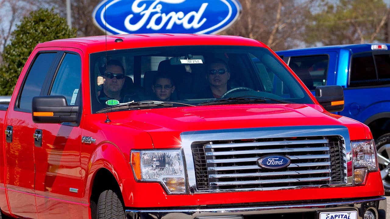 Family drives away from car dealership with a new truck