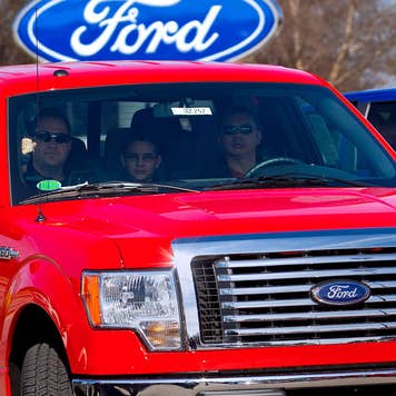 Family drives away from car dealership with a new truck