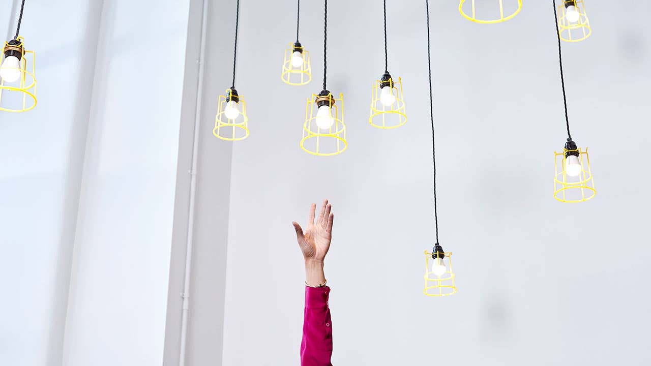 Woman reaching for light bulbs out of reach