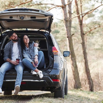 Couple sits in the back of their car together