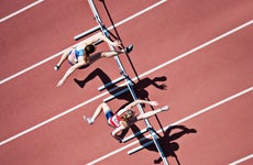 women jumping hurdles race