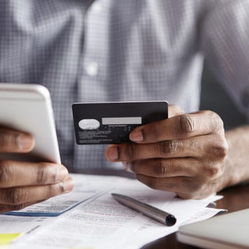 Man paying bill with credit card and phone