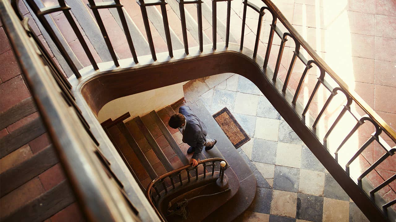 Man walking up spiral staircase