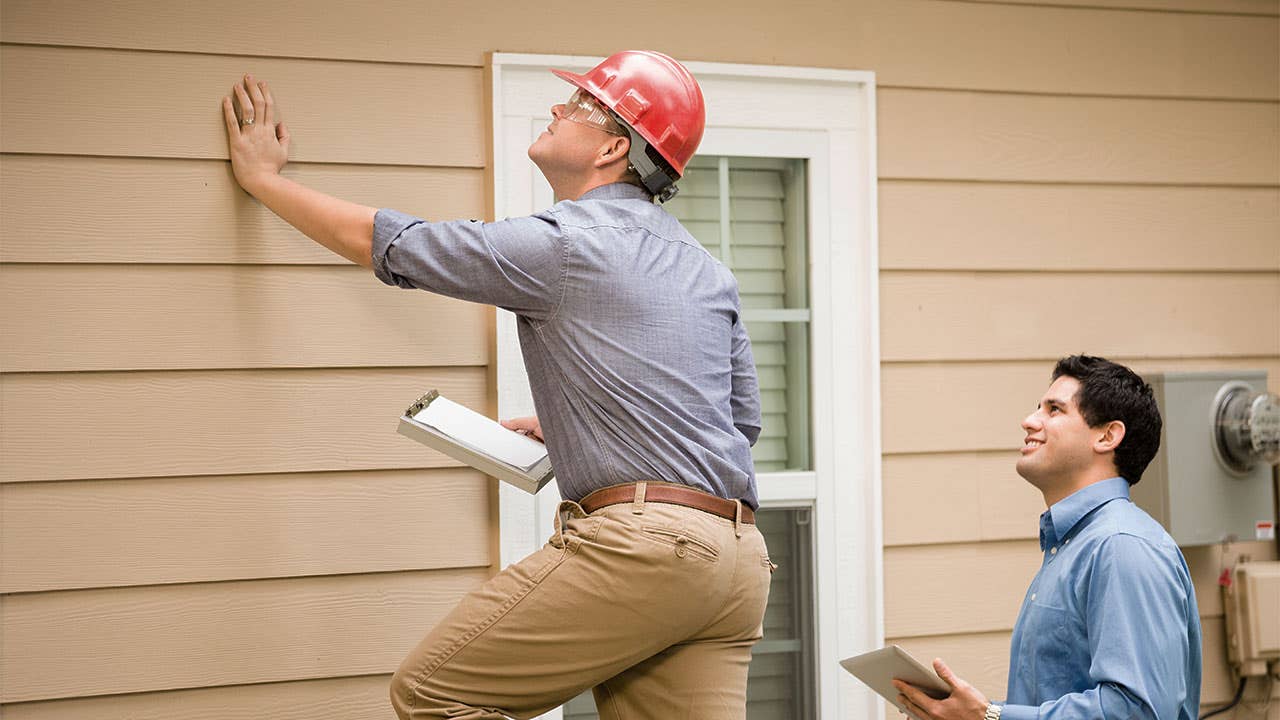 Two home appraisers examining a house