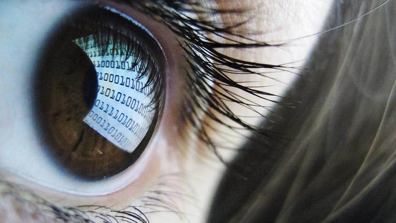 Close up of eye reflecting binary numbers