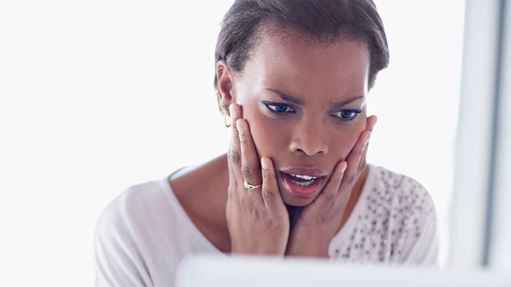 Shocked woman looking at her computer screen © iStock