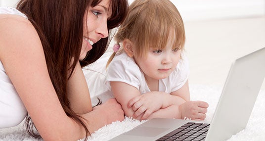 Mother with young daughter using computer