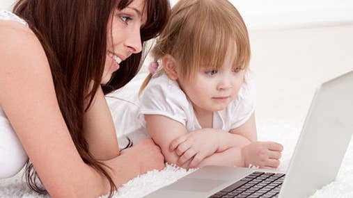Mother with young daughter using computer
