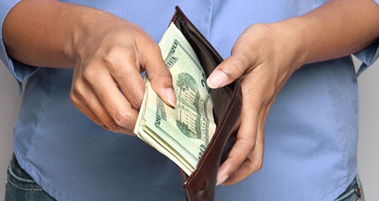 Woman in blue shirt opening wallet © PTstock/Shutterstock.com