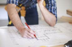 Man making changes to home blueprint © iStock.com