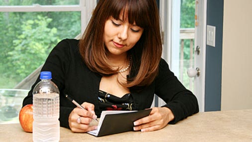 Young woman writing a check