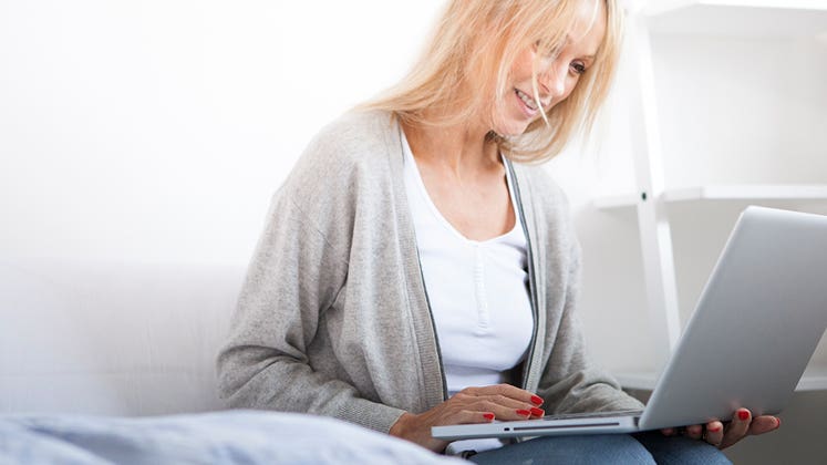 Woman smiling using her webcam © iStock