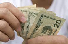Man counting bills in hand © Jason Stitt/Shutterstock.com
