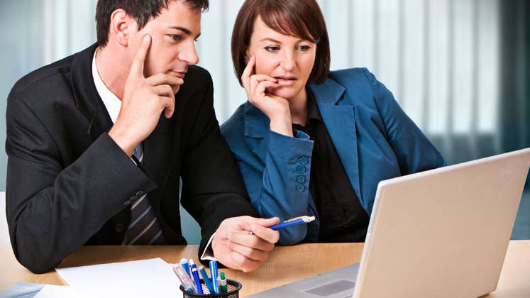 Couple sitting at a table looking at a computer © Patrizia Tilly/Shutterstock.com