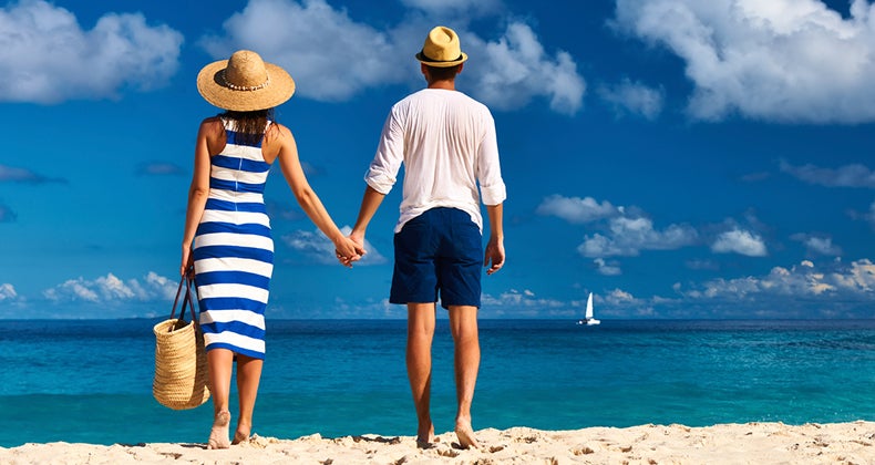 Couple holding hands on the beach © iStock