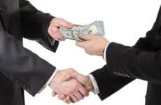 Businessmen exchanging money over deal © iStock