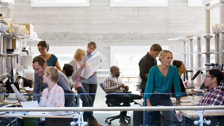 Co-workers busy in office | Compassionate Eye Foundation/Hero Images/Getty Images