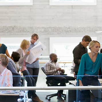 Co-workers busy in office | Compassionate Eye Foundation/Hero Images/Getty Images