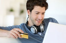 Young man holding credit card © Goodluz/Shutterstock.com