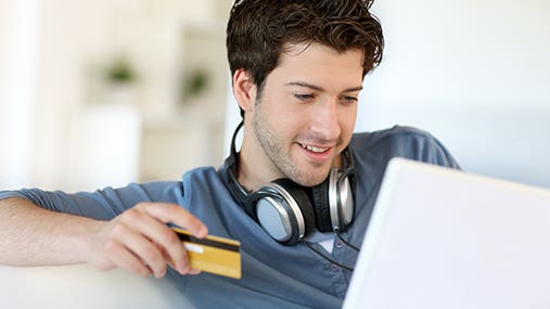 Young man holding credit card © Goodluz/Shutterstock.com