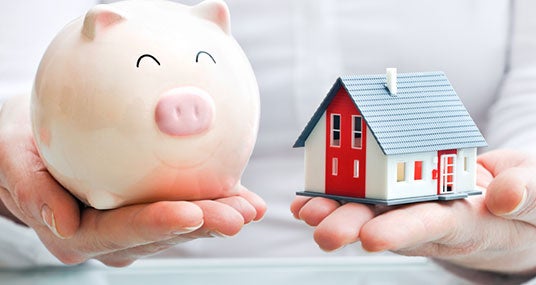 Hands holding piggy bank and house model © Alexander Raths/Shutterstock.com