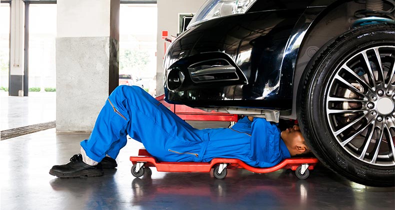 Auto mechanic working on car in shop | Twinsterphoto/Shutterstock.com