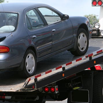 Car being lifted onto tow truck bed