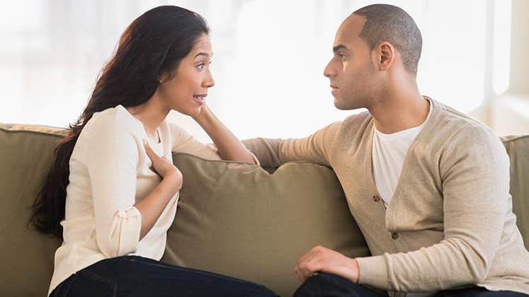 Young couple talking face-to-face in the couch | Tetra Images/Getty Images