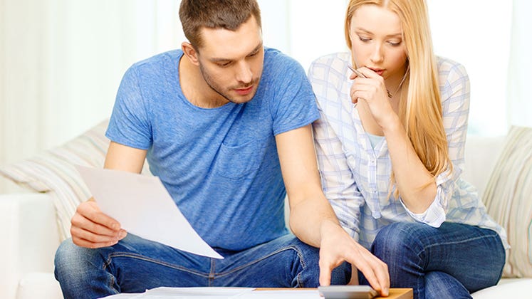 Busy couple with papers and calculator at home © Syda Productions/Shutterstock.com