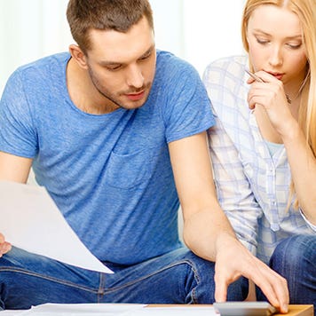 Busy couple with papers and calculator at home © Syda Productions/Shutterstock.com