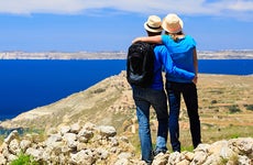 Young couple looking at scenic view from the mountains © iStock