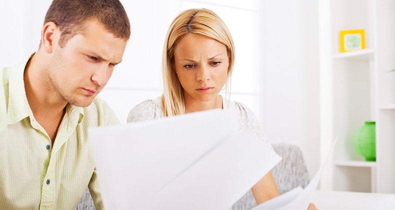 Couple seriously reading paperwork