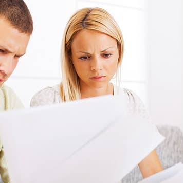 Couple seriously reading paperwork