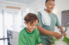 Dad and son doing dishes in kitchen | Hero Images/Getty Images