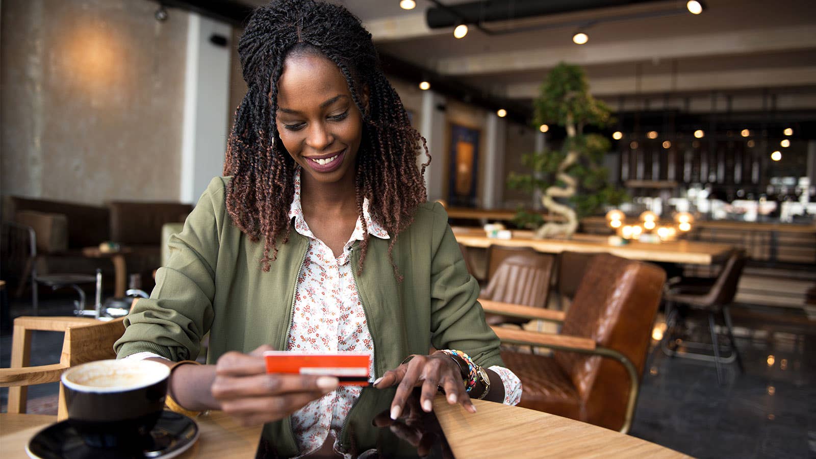 Woman at coffee shop putting credit card in her purse