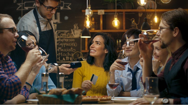 Group of friends enjoy wine together at dinner