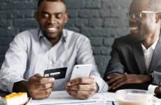 Two men at dinner and one paying with credit card