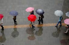 people walking through the rain with umberellas