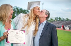 parents embrace at high school graduation