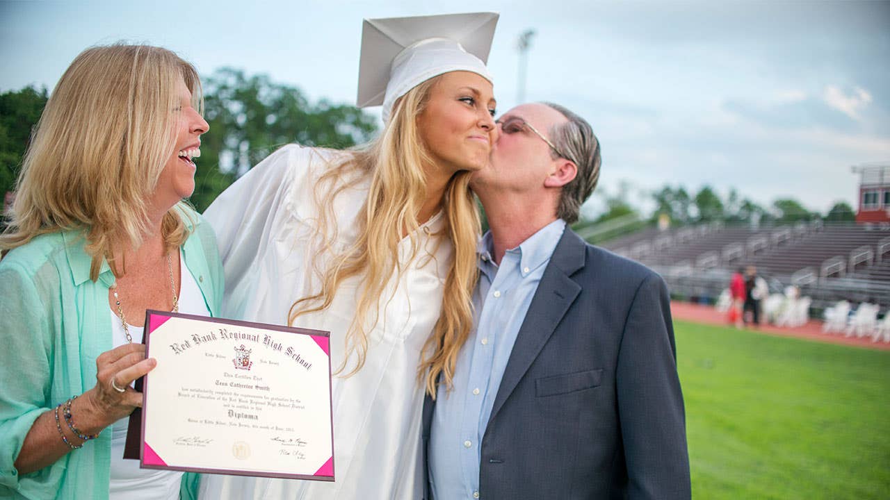 parents embrace at high school graduation