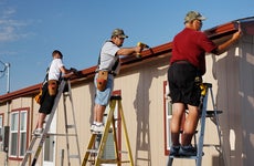 Three workers installing gutters