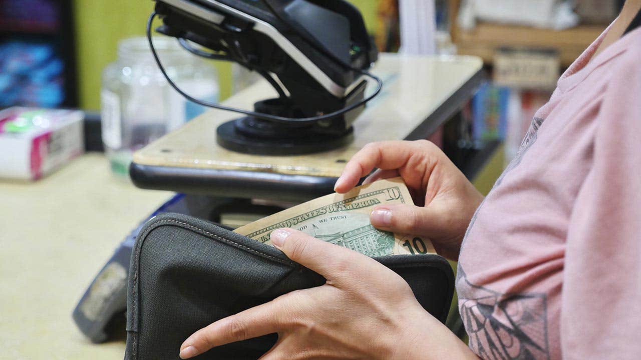 Woman taking a $10 bill out of her wallet