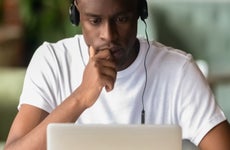 College student focuses on a laptop with headphones