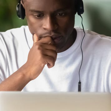 College student focuses on a laptop with headphones