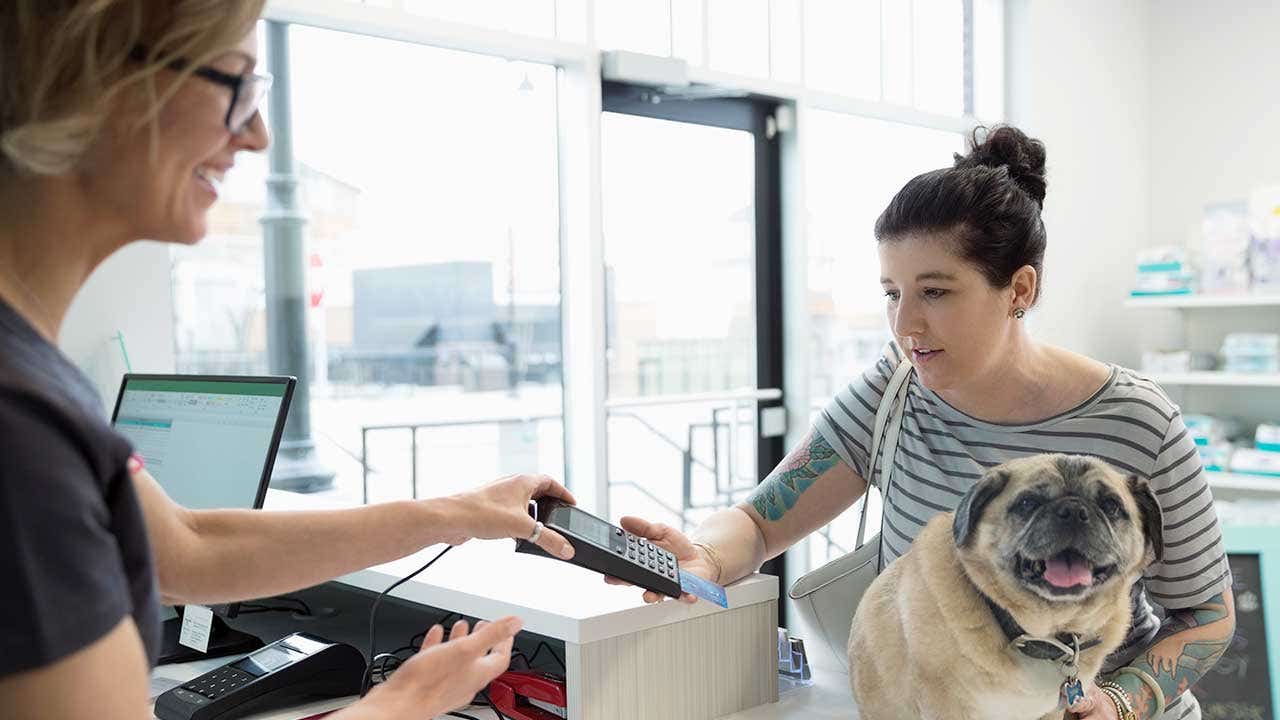 Woman paying with card in vet's office
