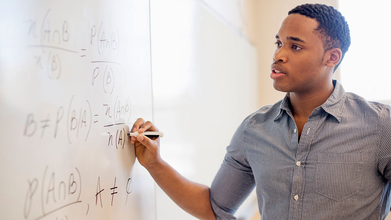 Man writing mathematic equation