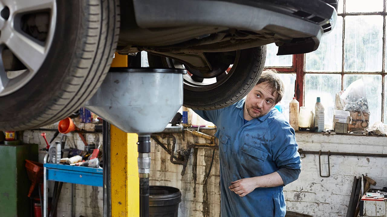 Mechanic looking under car